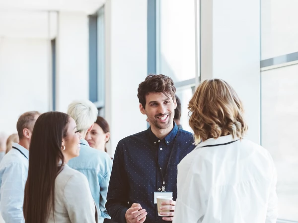 Menschen im Gespräch bei einem Firmenevent in heller Umgebung