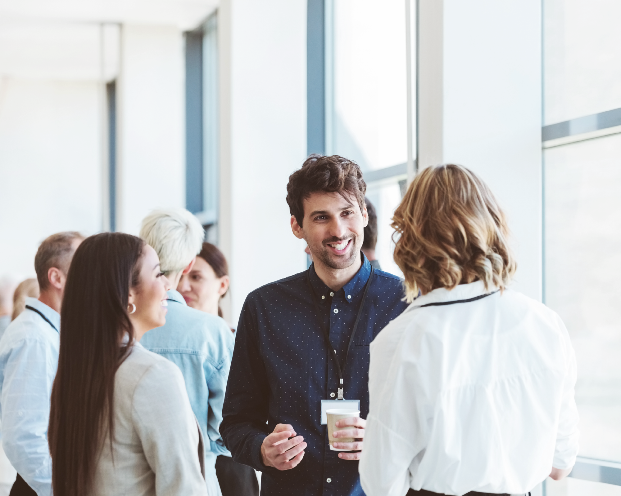 Menschen im Gespräch bei einem Firmenevent in heller Umgebung